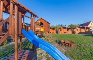 ein Spielplatz mit Rutsche im Hof in der Unterkunft Osada nad Dziwną domki nad morzem in Dziwnów