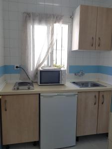 a kitchen with a sink and a microwave on a counter at Sunny Beach in Benalmádena