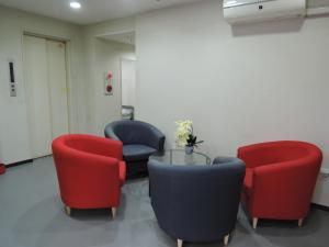 大阪市にあるHOTEL LUCKY / Vacation STAY 4268の赤と青の椅子とテーブルが備わる待合室