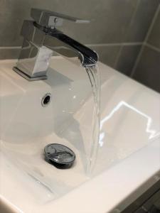 a sink with a water faucet on top of it at OnPoint - 2 Bed Apartment City Centre Ideal Location! in Nottingham