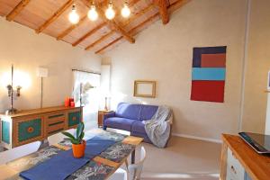 een woonkamer met een blauwe bank en een tafel bij Il Bozzolo Eco Boutique Apartments in Valeggio sul Mincio