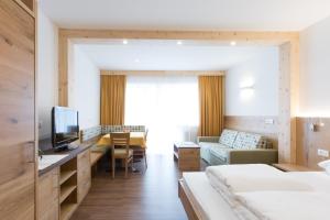 ein Hotelzimmer mit einem Bett und einem Wohnzimmer in der Unterkunft Hotel Appartement Inge in Dorf Tirol