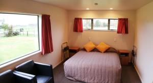 A bed or beds in a room at Glacier View Motel - Franz Josef