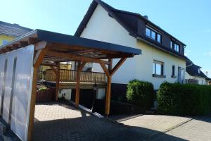 a wooden pergola in front of a house at Ferienwohnung in Dierdorf in Dierdorf