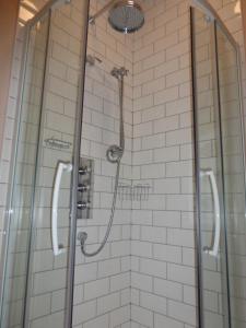 a bathroom with a shower with glass doors at Home Farm House in Wimborne Saint Giles