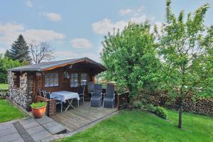 eine Hütte mit einem Tisch und Stühlen auf einer Terrasse in der Unterkunft Ferien- und Messewohnung/ Apartment in Wahlscheid