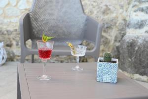 two wine glasses and a cactus on a table at La Torre del Mulino - SUPERIOR Rooms in Tropea