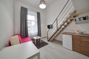 sala de estar con silla roja y escalera en Heart of Downtown Apartment, en Budapest