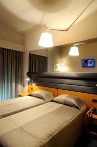 スパルティにあるManiatis Hotelのベッド2台 ホテルルーム ランプ2つ付