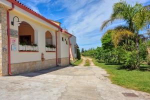 un bâtiment avec une route à côté d'un palmier dans l'établissement Agriturismo Il Piccolo Lago, à Otrante