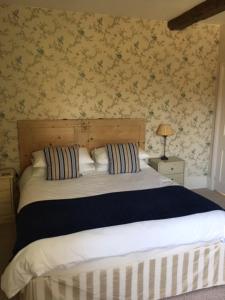 a bedroom with a large bed with a wooden headboard at Home Farm House in Wimborne Saint Giles