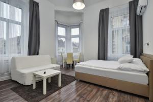 Un dormitorio con una cama, un sofá y una mesa. en Heart of Downtown Apartment, en Budapest
