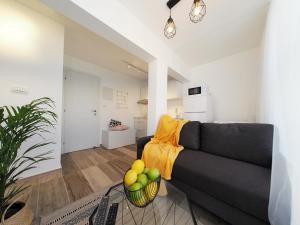 a living room with a couch and a bowl of fruit at Studio Ariana and patio in Bat Yam