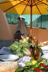 une table avec des plaques alimentaires et un parapluie jaune dans l'établissement Appartamenti Villa Chiara, à Imperia