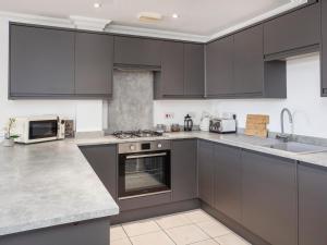 a kitchen with gray cabinets and a sink at Fountains view Apartment in York +13 photos