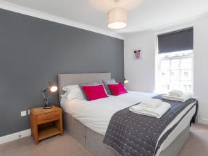 a bedroom with a large bed with red pillows at Fountains view Apartment in York