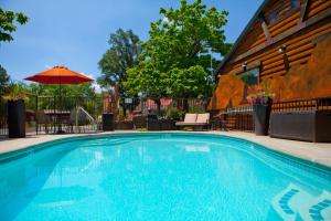 a swimming pool with an umbrella next to a building at Canyons Lodge- A Canyons Collection Property in Kanab