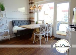 a kitchen with a table and chairs and a couch at INSELMARIE Wangerooge in Wangerooge