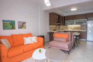 salon z pomarańczową kanapą i stołem w obiekcie Katia Appartment w mieście Ajos Nikolaos