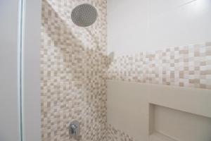 a bathroom with a shower with brown tiles at RedDoorz near MT Haryono Semarang in Semarang