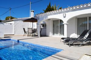 a patio with chairs and a swimming pool in front of a house at Anacasa Villa Bacalla Piscina Privada Les Marines CH3200 in Denia