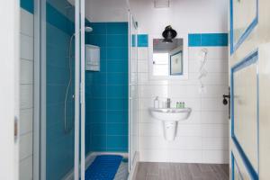 a blue and white bathroom with a sink and a shower at Casato Bapo camera panoramica Aurora in Riomaggiore +8 photos
