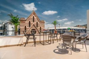 a patio with chairs and a table and a church at Diuma Hotel in Tbilisi City