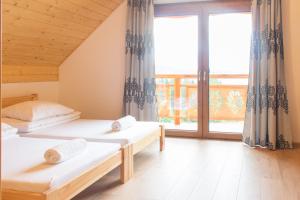 1 dormitorio con 2 camas y ventana grande en Domki w Kasinie en Kasina Wielka