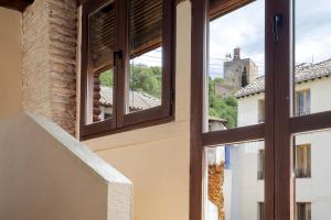 ein offenes Fenster mit Blick auf ein Gebäude in der Unterkunft Urban Suites Granada in Granada