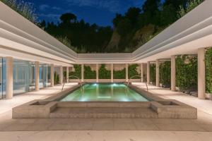 an indoor swimming pool in a building with a ceiling at Hotel Balneari Termes Orion in Santa Coloma de Farners