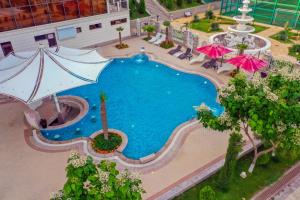 an overhead view of a large swimming pool with umbrellas at Parliament Palace Hotel in Khujand