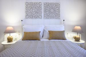- une chambre avec un lit blanc et 2 lampes dans l'établissement Mirabeli Apartments & Suites, à Pollonia