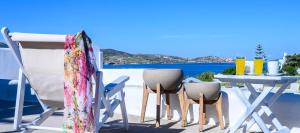 a table and chairs on a balcony with a view of the ocean at Mirabeli Apartments & Suites in Pollonia