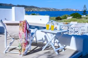 a white table and chairs with drinks on it at Mirabeli Apartments & Suites in Pollonia