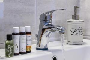 a sink with a faucet and three bottles of soap at Mirabeli Apartments & Suites in Pollonia