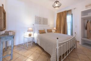 a bedroom with a large white bed and a table at Mirabeli Apartments & Suites in Pollonia