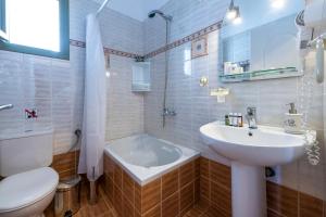 a bathroom with a sink and a tub and a toilet at Mirabeli Apartments & Suites in Pollonia