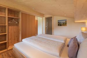 a bedroom with a large white bed in a room at Ferienwohnungen stiLECHt in Elbigenalp