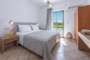 a bedroom with a bed and a large window at Mirabeli Apartments & Suites in Pollonia