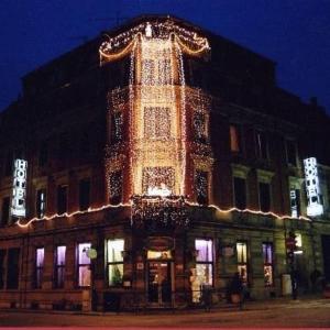 Un grand bâtiment avec des lumières allumées la nuit dans l'établissement Hotel Union, à Sarreguemines