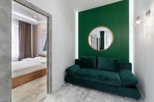 a green room with a mirror and a green couch at LEOGRAND LOFT Apartments on Lychakivska 4 in Lviv