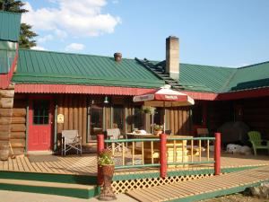 a restaurant with a deck with a table and an umbrella at Summit River Lodge & Campsites in Valemount