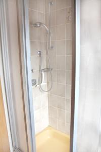 a bathroom with a shower with a yellow tub at Ruhige Unterkunft nahe der Nordsee in Friedeburg