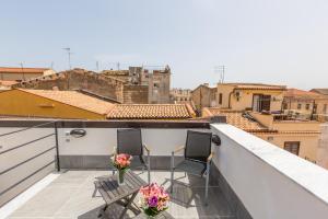 balkon z 2 krzesłami i widokiem na miasto w obiekcie Mosina Apartments w mieście Palermo