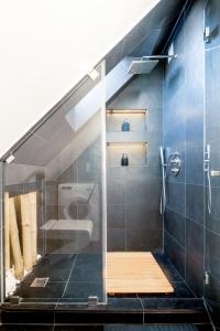 uma casa de banho com uma cabina de duche ao nível do chão e uma escada em Stylish, modern apartment near Vilnius Old Town em Vilnius