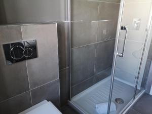 a shower with a glass door in a bathroom at Pep's Rooms by the sea in Trieste