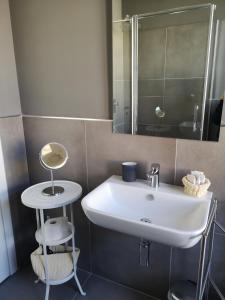 een badkamer met een witte wastafel en een spiegel bij Pep's Rooms by the sea in Trieste