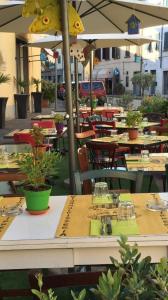 un restaurante al aire libre con mesas, sillas y sombrillas en Affittacamere Come a Casa, en Borgo a Buggiano