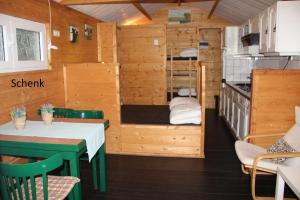a kitchen and a dining room with a table in a tiny house at Chalet - Camping 't Dekske in Wintelre