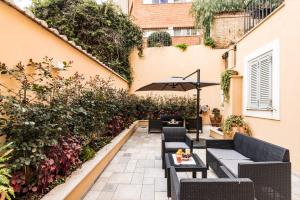 patio z krzesłami i parasolem w obiekcie Dolcevita Apartments w Rzymie